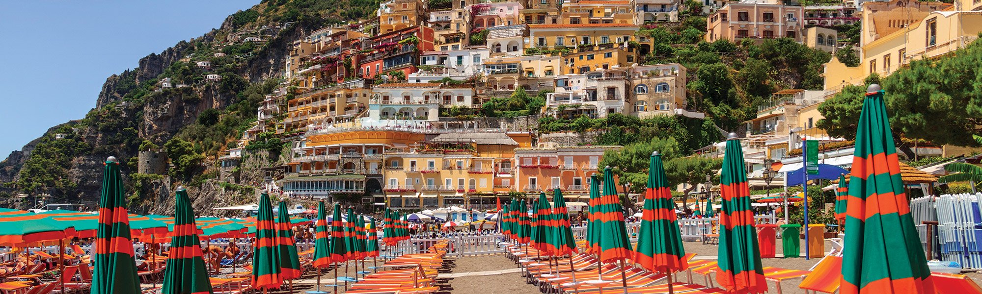 Image of a beach on the Amalfi Coast next to a cliff covered in brightly painted buildings