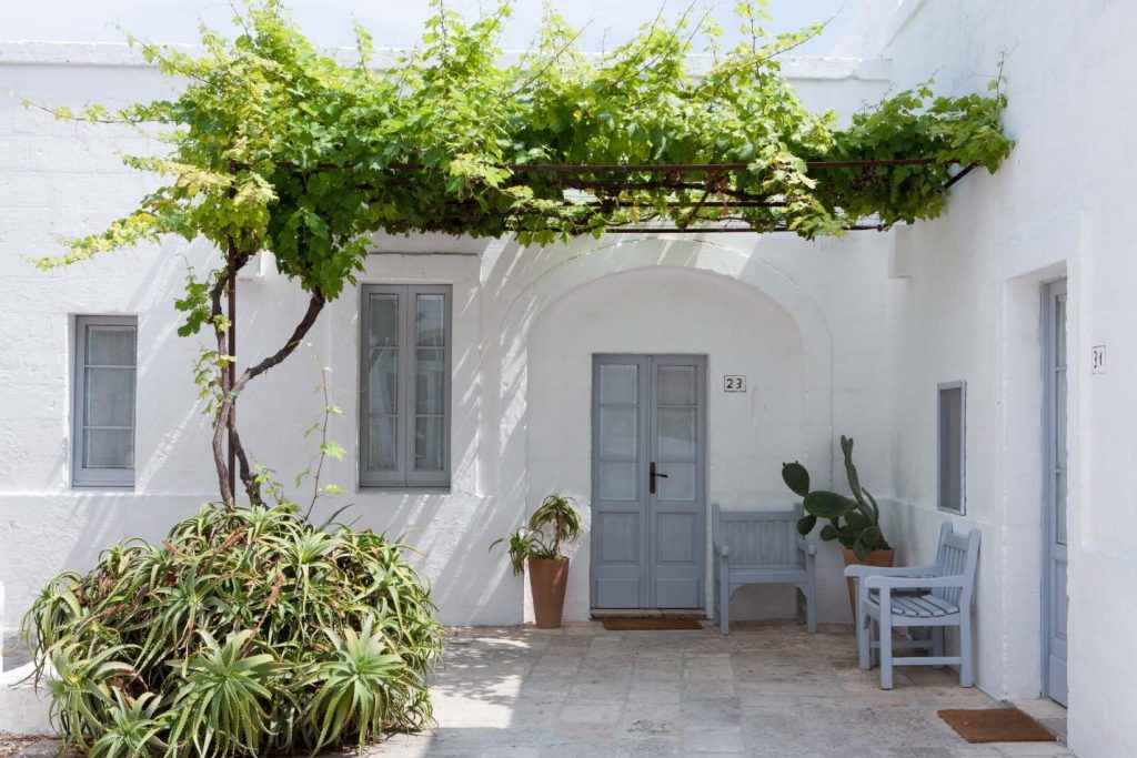 A white entryway surrounded by foliage