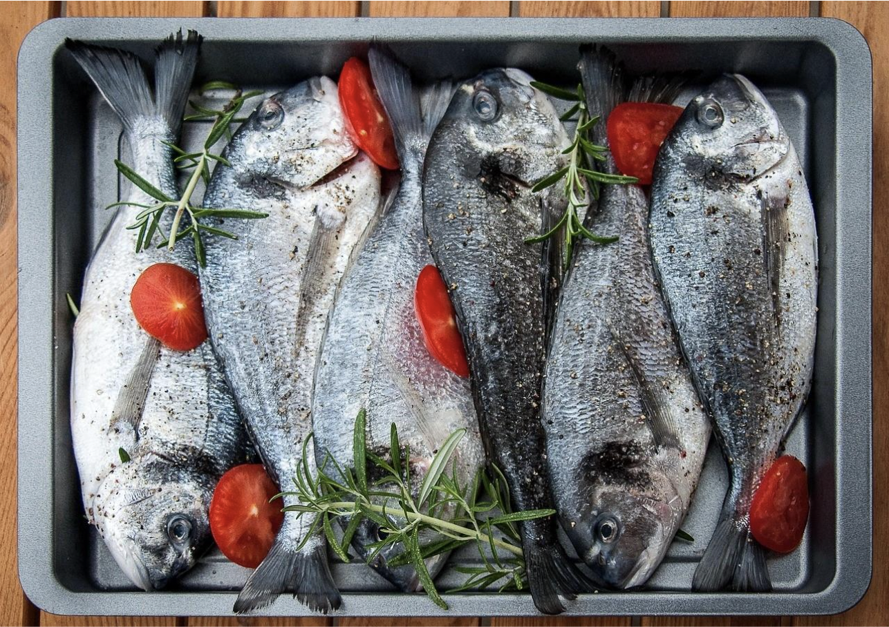 Fishes in a pan with herbs and tomatoes for the Feast of the Seven Fishes