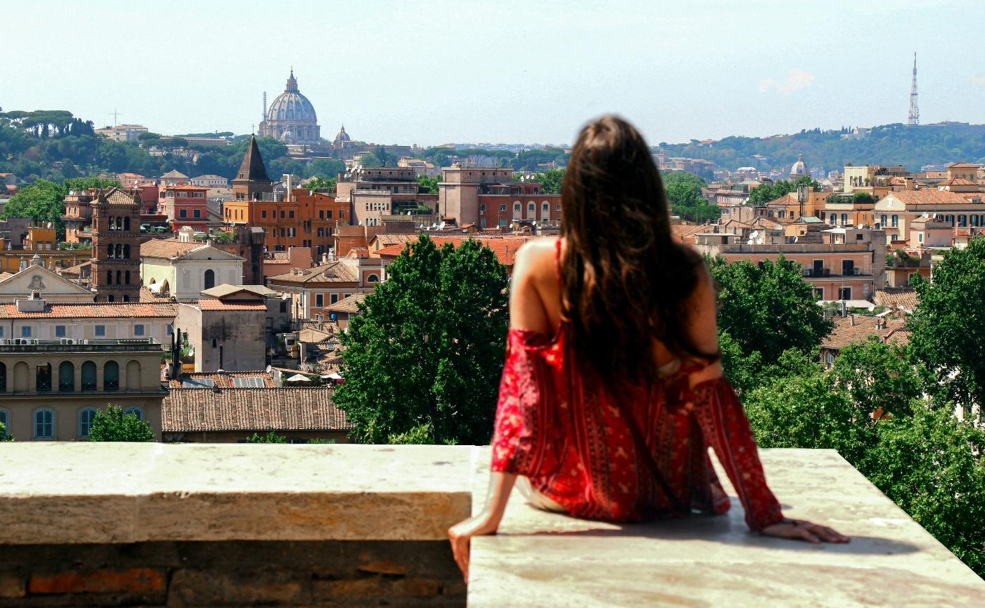 Woman overlooking Rome skyline with St. Peter’s Basilica in the distance, capturing an Emily in Rome travel moment